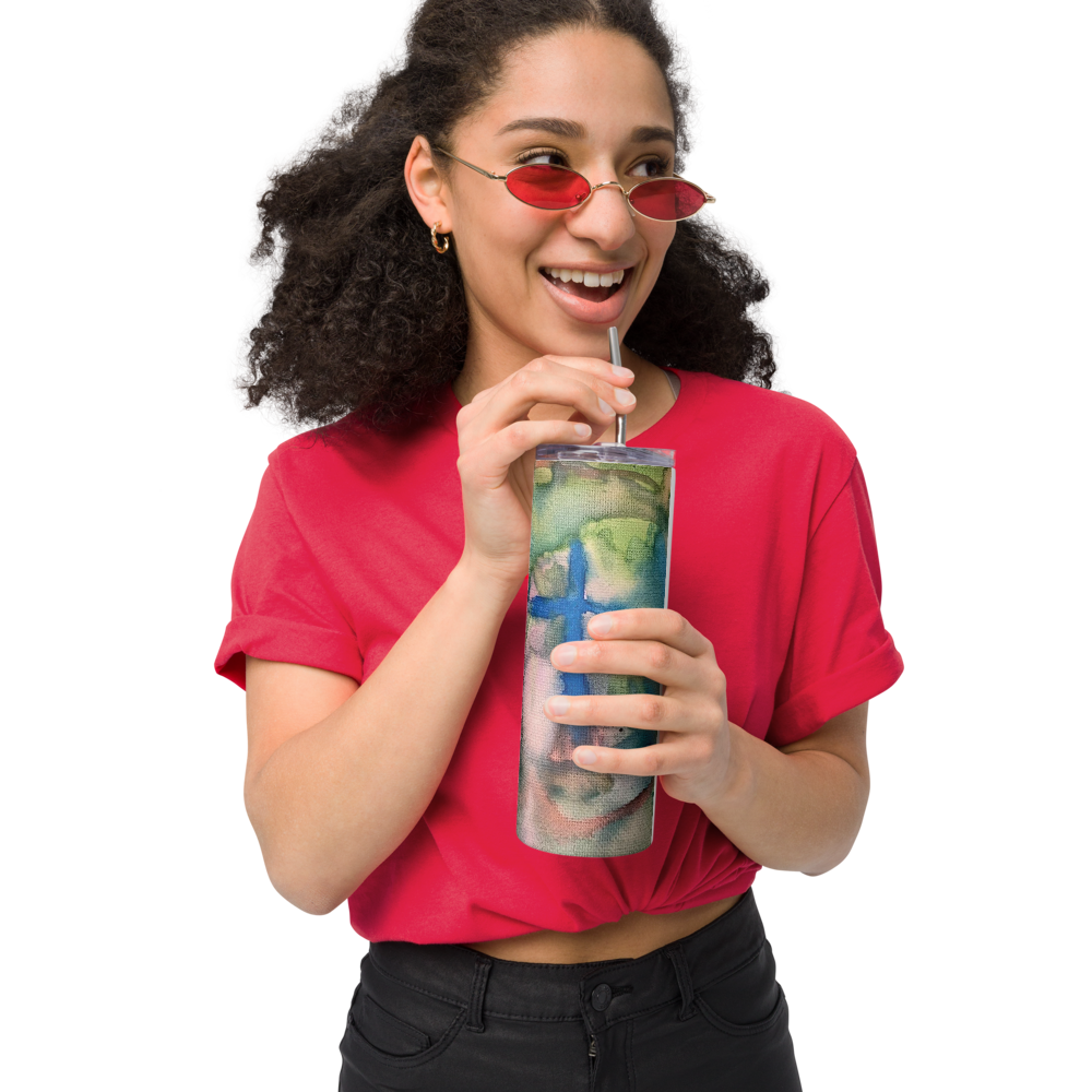 Watercolor tumbler design featuring a vibrant blue cross against a green and yellow watercolor background held by a woman wearing red sunglasses
