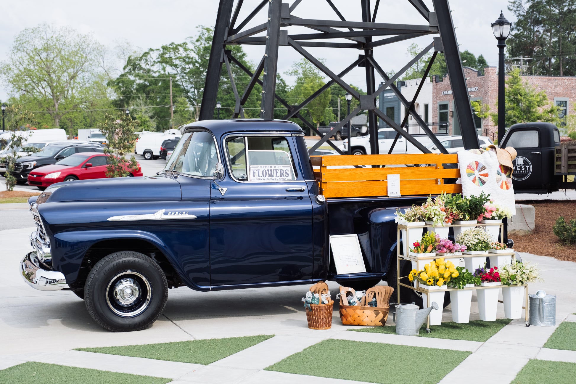 The RENTAL: Flower Display Stand with Buckets from Blessings Grow Meadows Merch & More is perfect for weddings or events, featuring shelves for fresh locally grown bouquets and gardening tools; available for pick-up in Metter, GA.