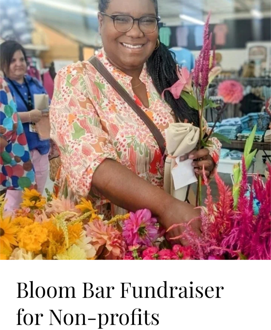 Photograph of a woman wearing a floral shirt arranging vibrant sunflowers dahlias and amaranth at a Bloom Bar fundraiser for nonprofits
