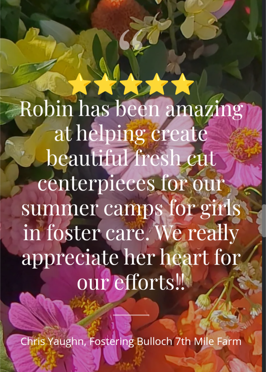 Photo of vibrant pink, orange, and yellow zinnias and other flowers possibly by an unknown artist showcasing a colorful floral arrangement.
