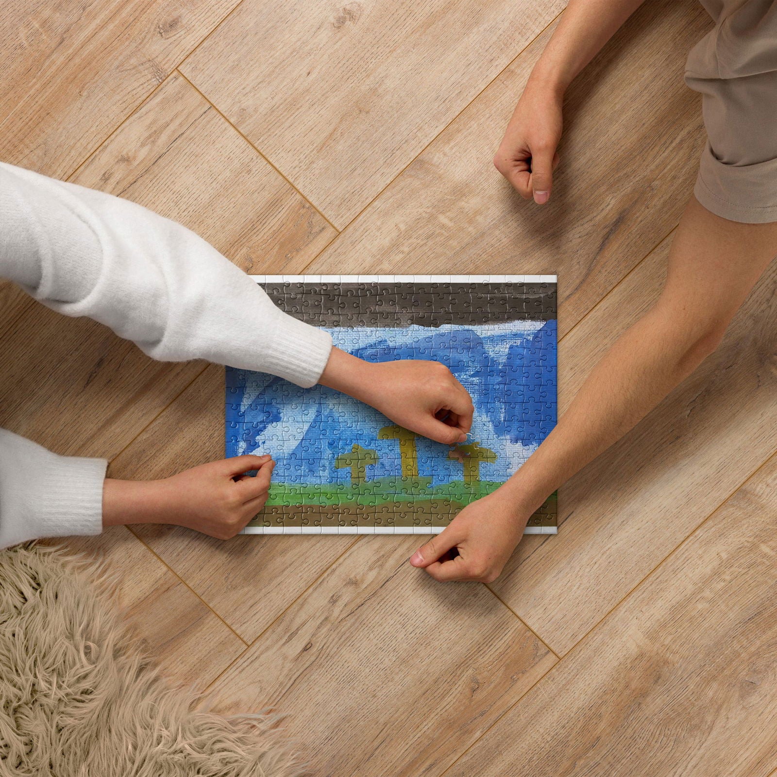 Jigsaw puzzle depicting a vibrant landscape with mountains and a blue sky featuring white clouds and green fields being assembled on a wooden floor by two people