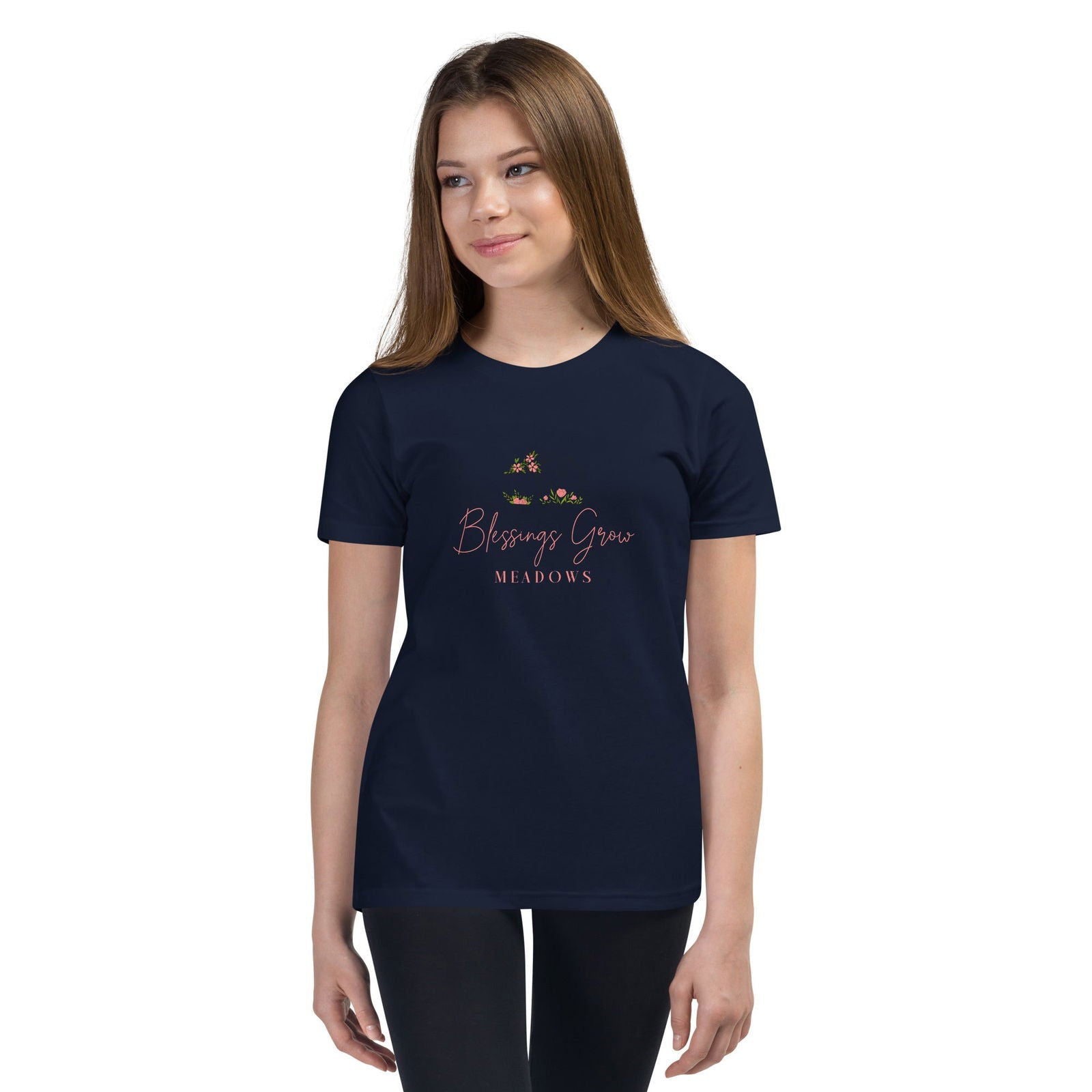 Apparel graphic design featuring a navy blue t-shirt with a pink and green floral logo that says Blessings Grow Meadows