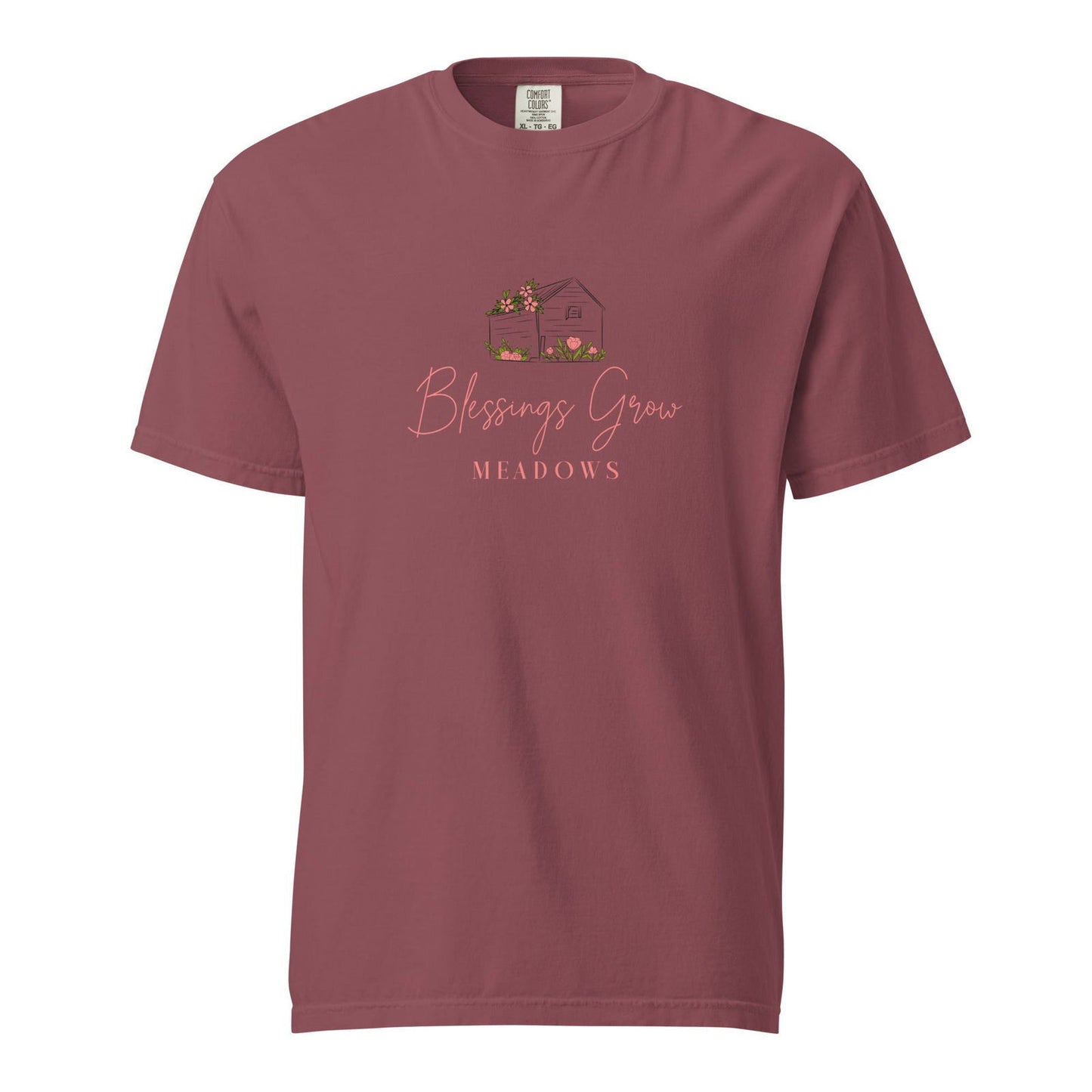 Comfort Colors maroon t-shirt featuring a Blessings Grow Meadows design of a charming house with pink flowers and tulips
