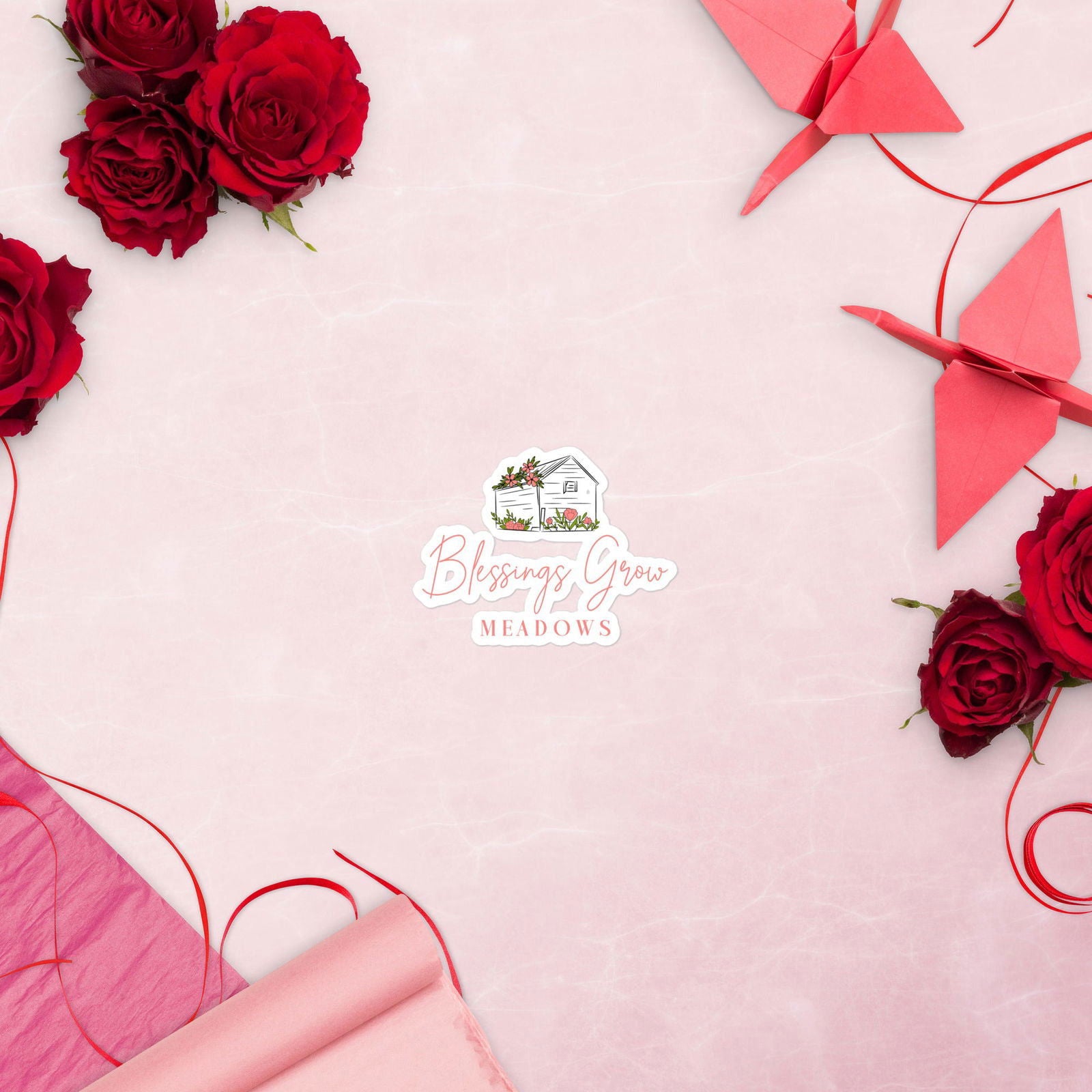 Digital illustration Blessings Grow Meadows logo featuring vibrant red roses, delicate pink paper, and origami cranes on a pink background.
