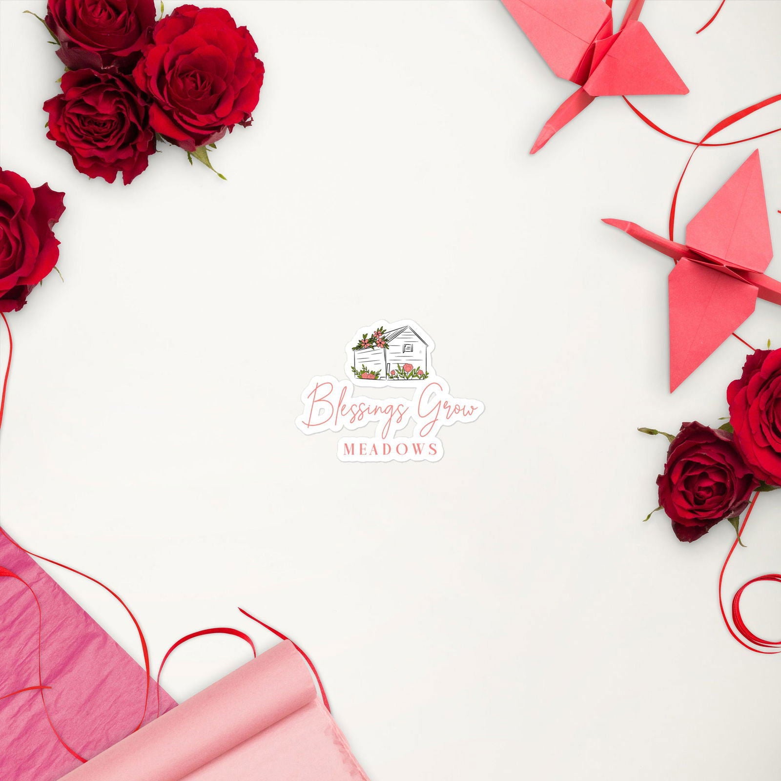 Digital illustration Blessings Grow Meadows logo featuring a charming cottage surrounded by vibrant pink flowers red roses and origami cranes on a white background
