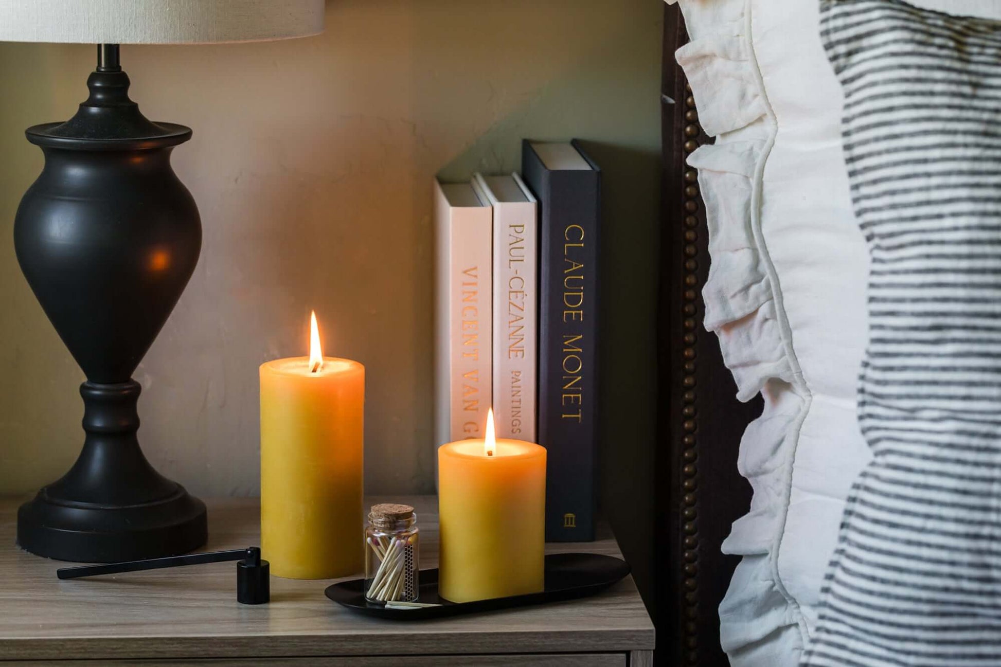 Bluecorn Candles pure beeswax pillar candles with matches, displayed next to a bed for a cozy, natural ambiance.