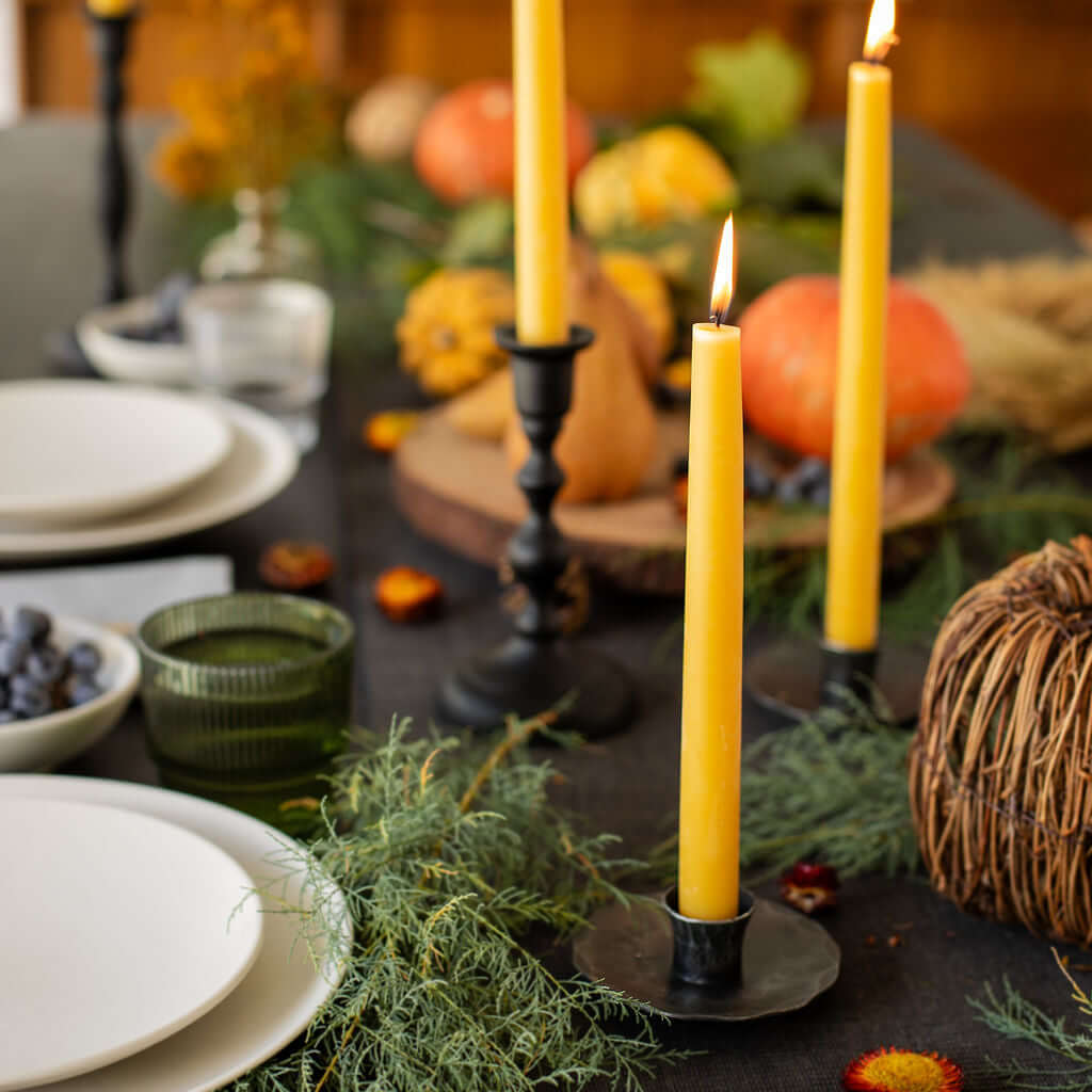 Bluecorn Candles hand-dipped beeswax taper candles on a fall table, showcasing the warm, natural honey-colored wax and elegant design.