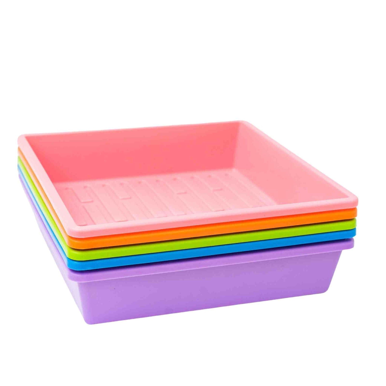 Plastic trays in pink orange green blue and purple tones stacked on a white background showing ribbed texture and vibrant colors

