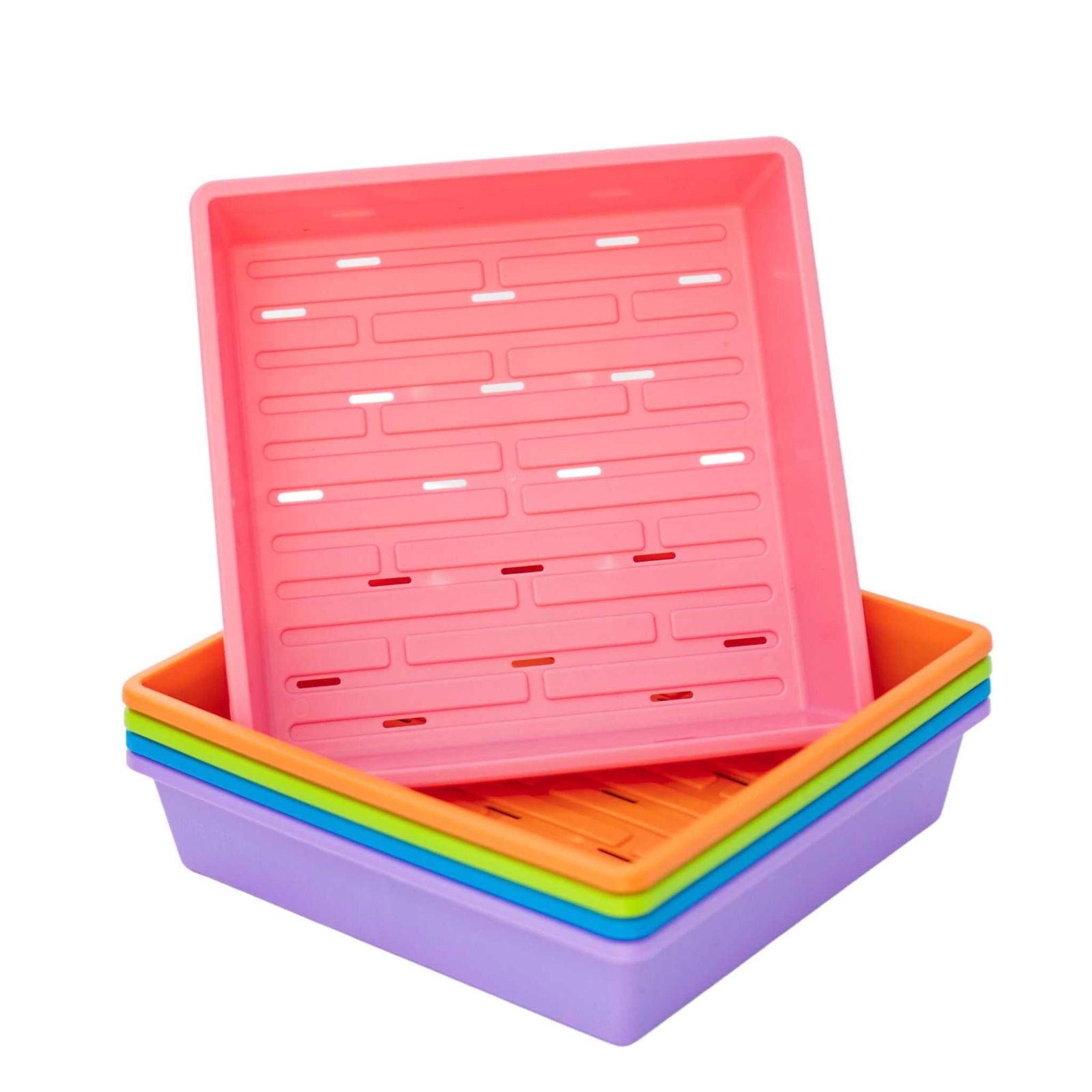 Plastic stackable seed starter trays in pink orange green and purple showing drainage holes and a grid pattern for seedlings.
