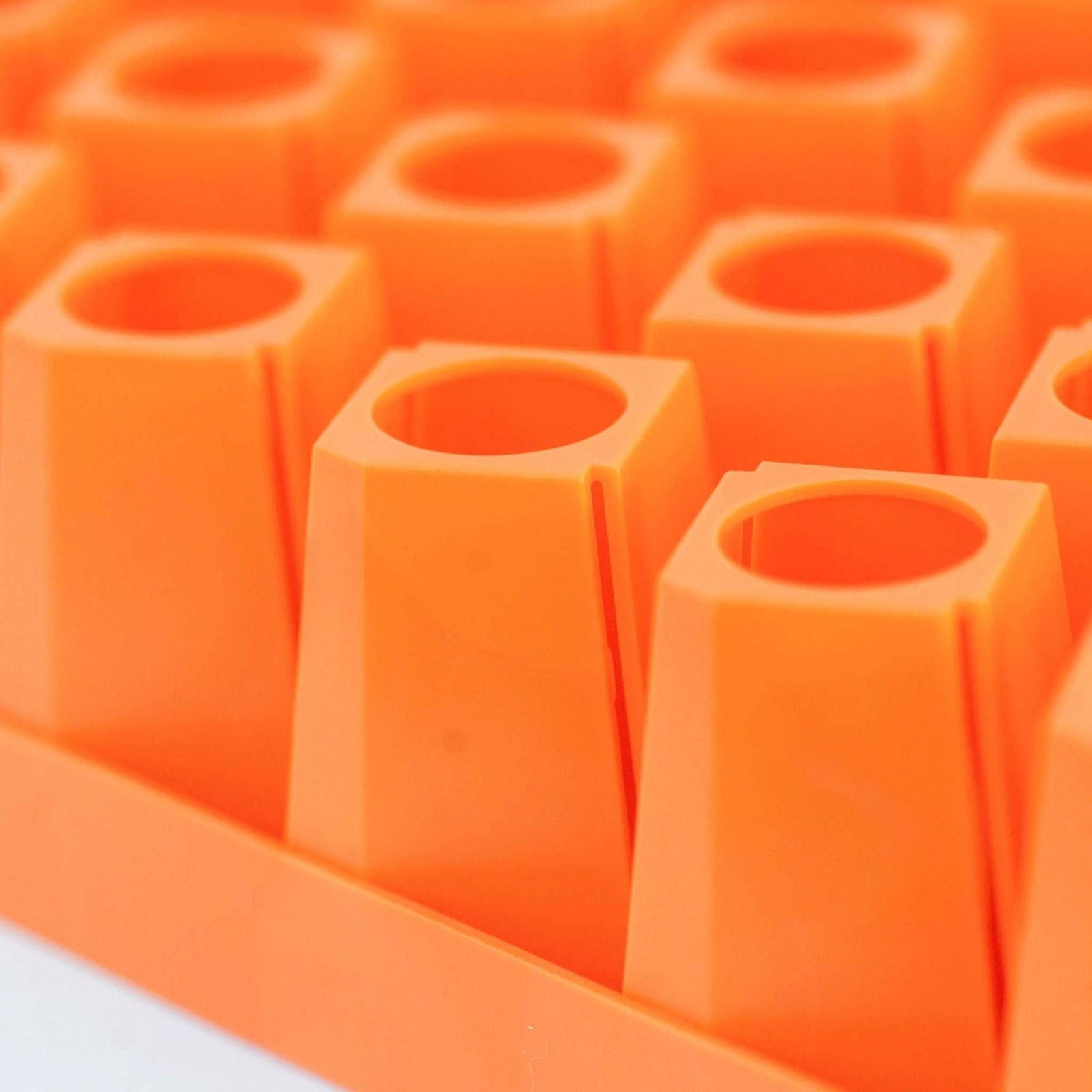 Plastic tray of vibrant orange seedling starter cells showing geometric shapes and subtle textures
