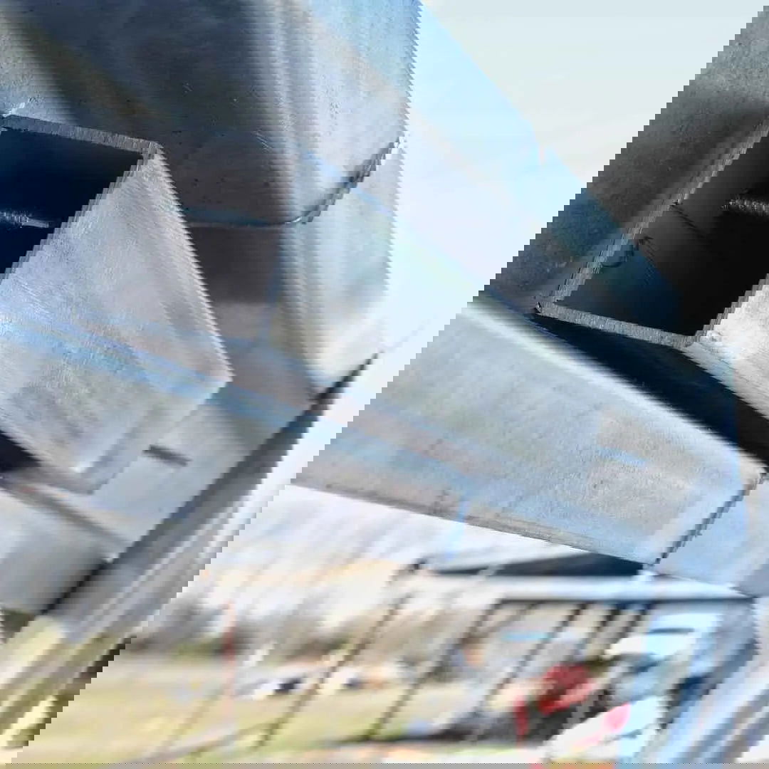 Close-up of Greenhouse Steel Hip and Brace Channel by Bootstrap Farmer intersecting at sharp angles, with a glitch effect—evoking enhanced wind and snow protection. The blurred background shows faint outdoor elements and subtle colors.