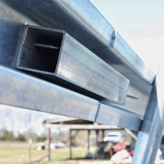 Close-up of Greenhouse Steel Hip and Brace Channel by Bootstrap Farmer intersecting at sharp angles, with a glitch effect—evoking enhanced wind and snow protection. The blurred background shows faint outdoor elements and subtle colors.