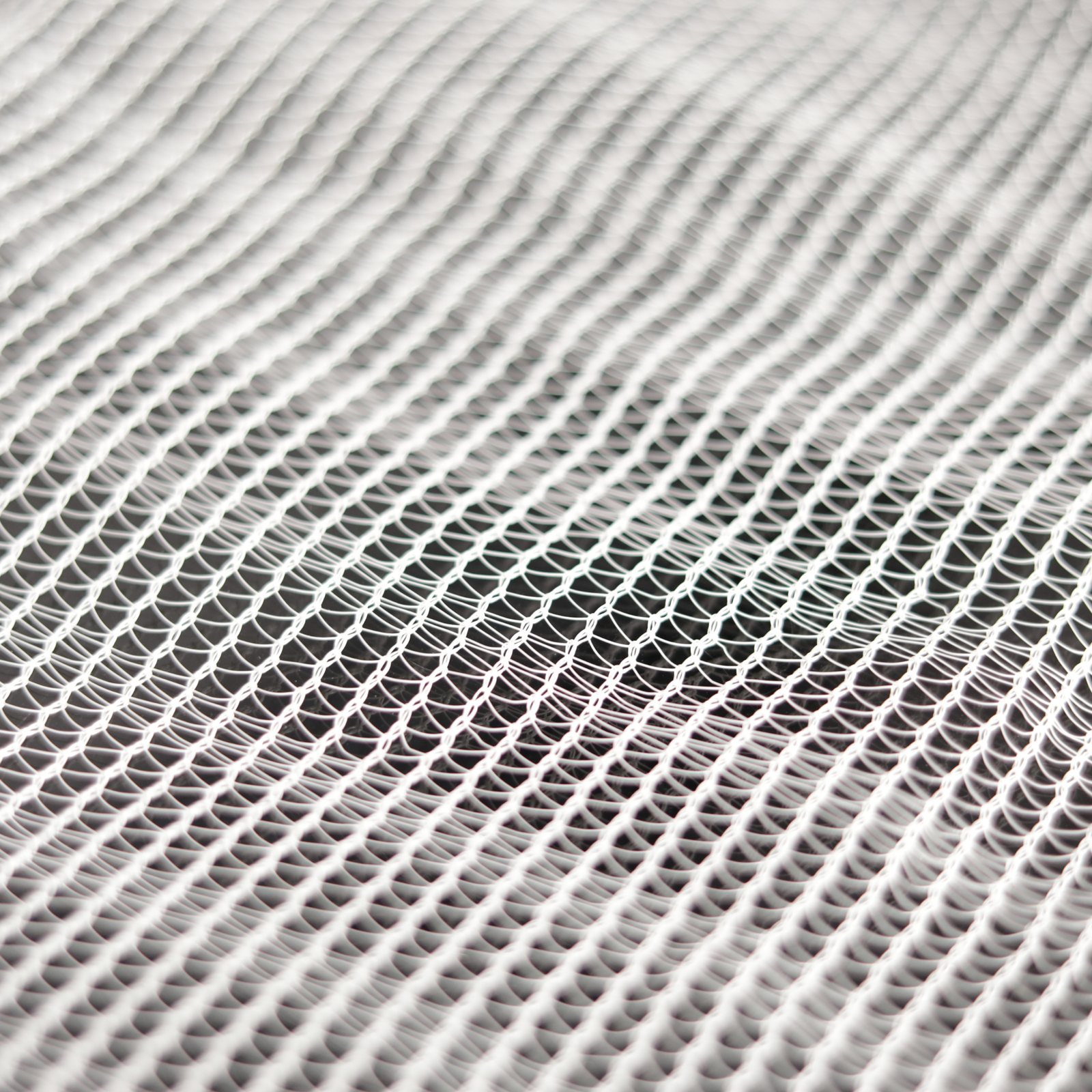 Abstract textile artwork depicting a white net-like fabric with a subtle wave pattern showing delicate interlacing and varying shades of gray and white.
