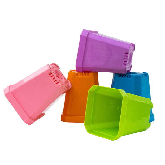 Five vibrant Bootstrap Farmer 5" Heavy Duty Seed Starting Pots—pink, orange, purple, blue, and green—are stacked and tipped playfully against a white background.