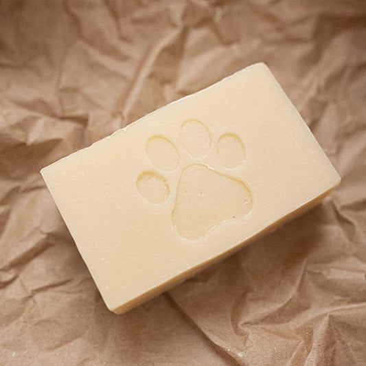 A 4oz rectangular Pet Shampoo Bar by ZeroWasteStore.com, all natural, vegan, and plastic free, featuring a paw print design and displayed on crumpled brown paper.