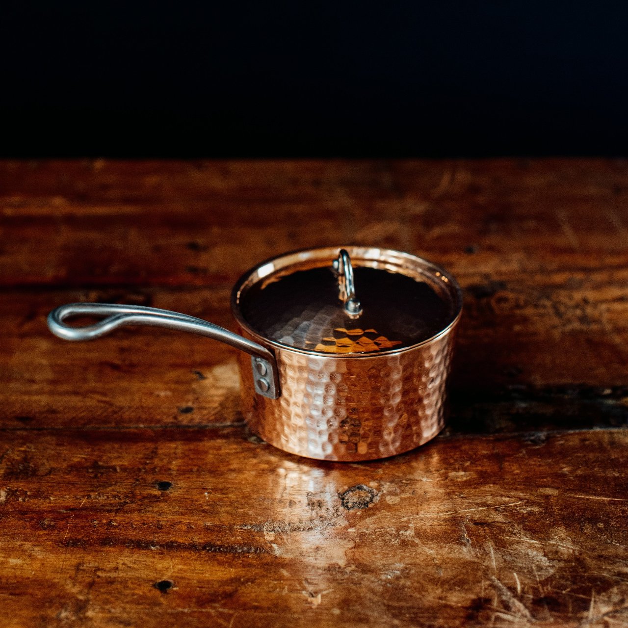 Petite French copper butter pot with handle and lid by Sertodo, showcasing shiny copper surface and traditional design.