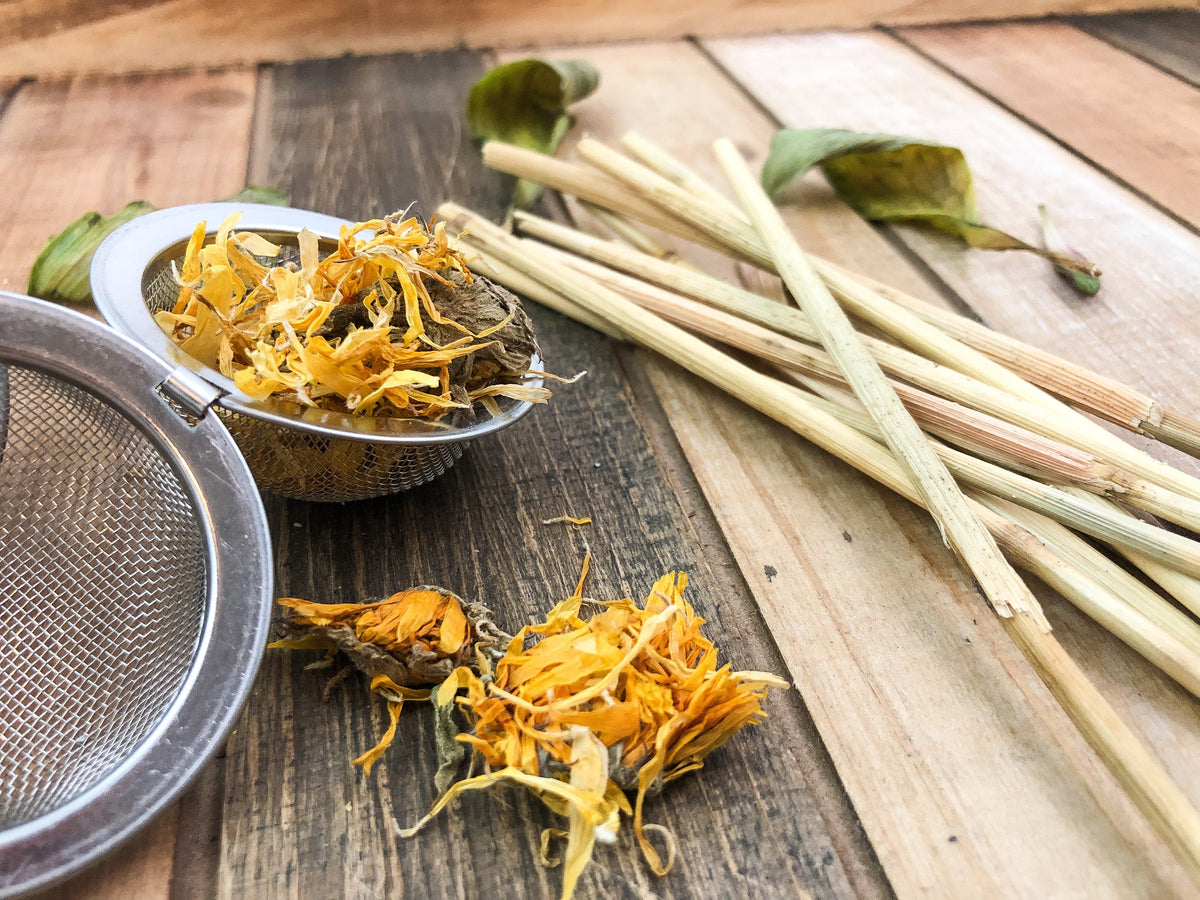 Herbalroseapothecary tea ball infuser filled with dried calendula flowers for herbal tea brewing.