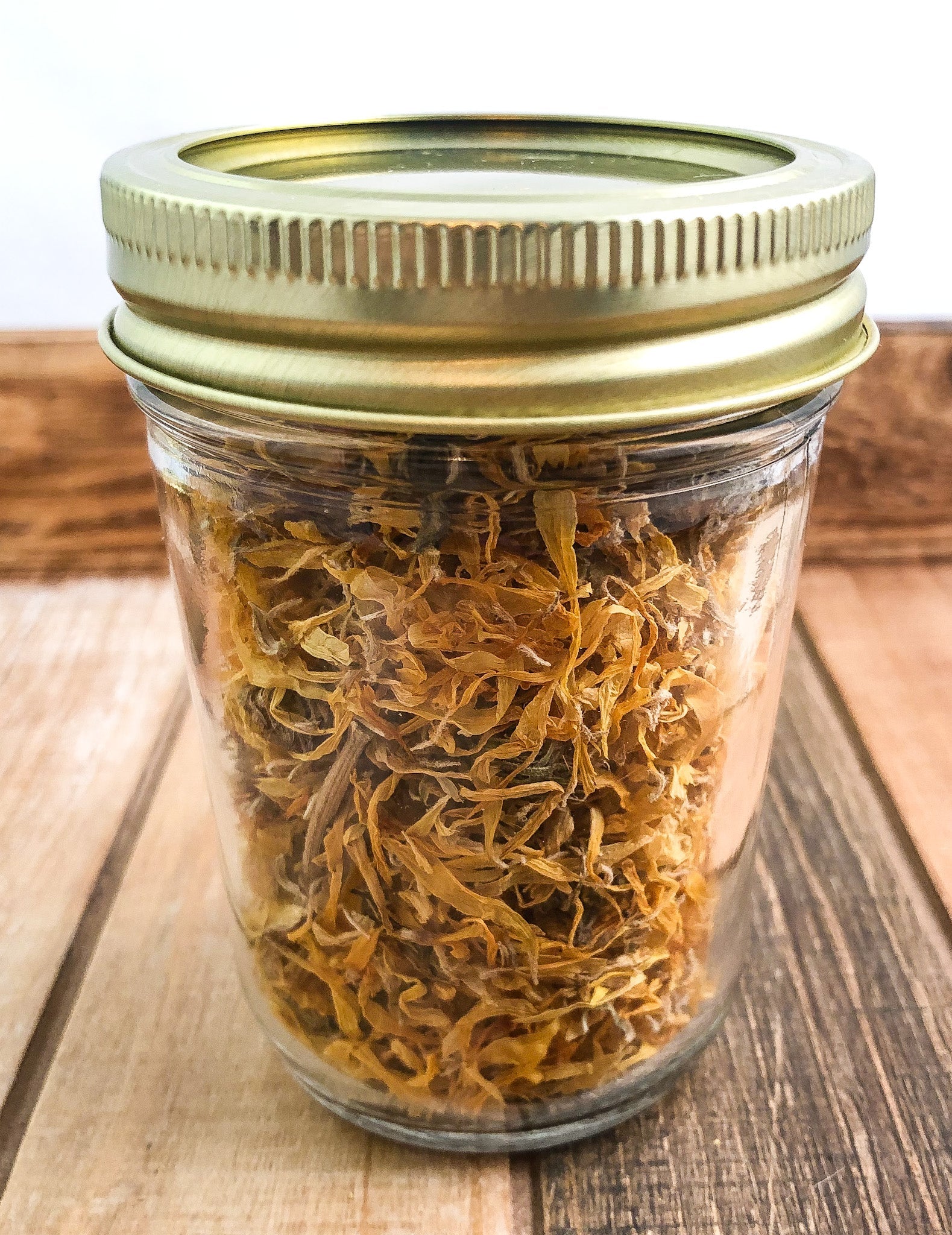 Small herbal herb jar by HerbalRoseApothecary containing dried calendula flowers in a wood and white container