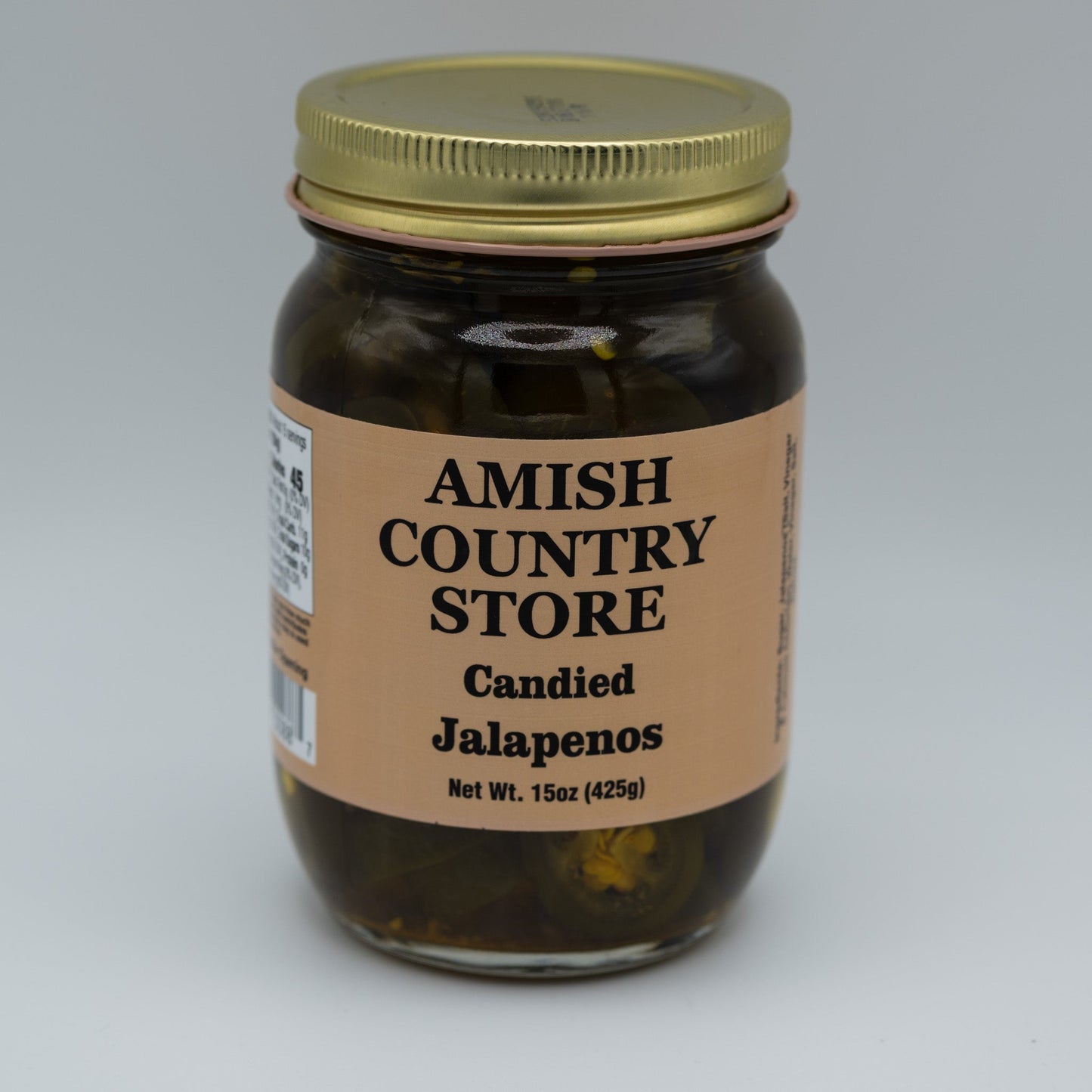 Canned candied jalapenos in a jar showing glossy, sliced jalapenos coated with sweet glaze, from Amish Country Store canned goods.