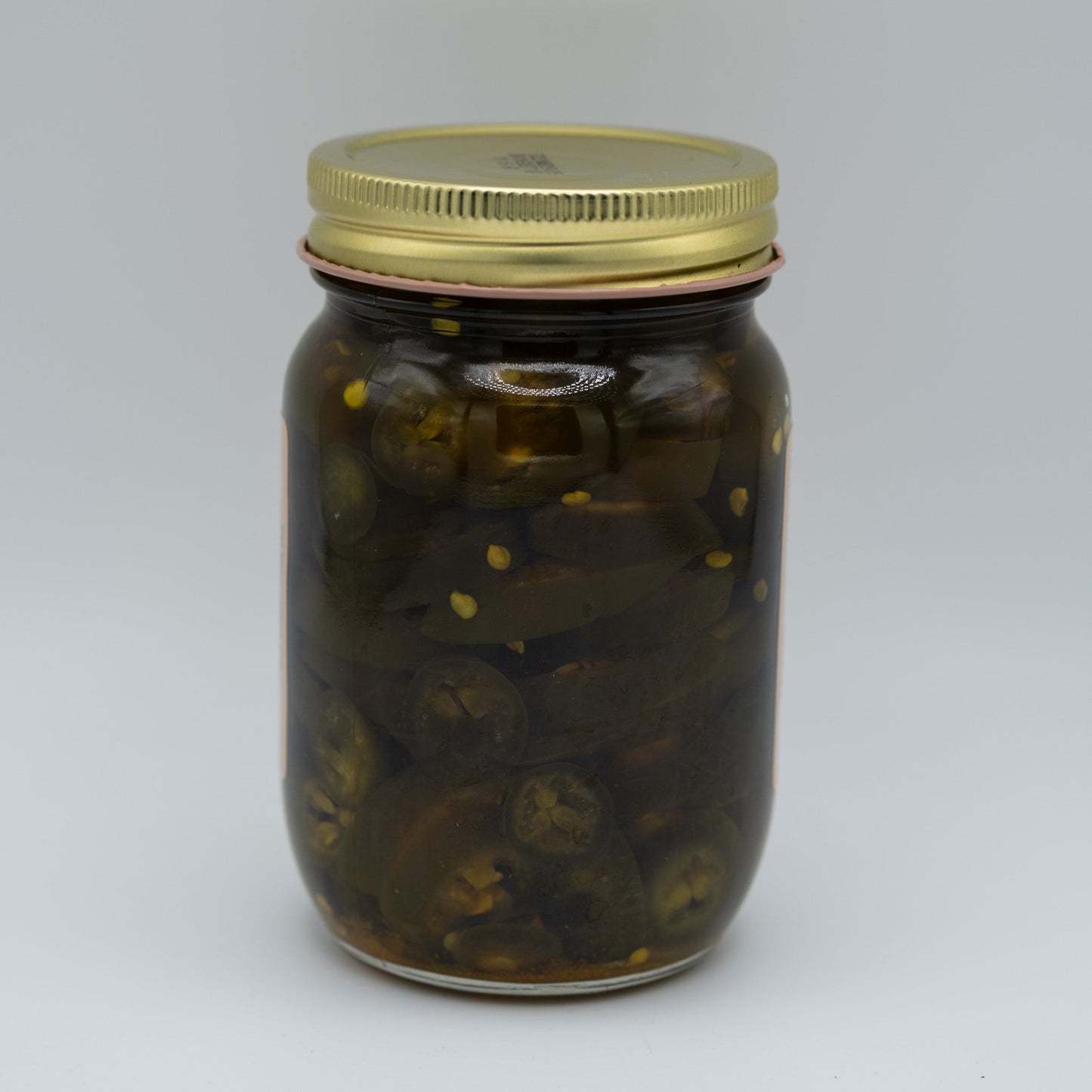 Canned candied jalapenos in a jar, Amish Country Store branded, showing glossy green jalapenos coated with sweet syrup.