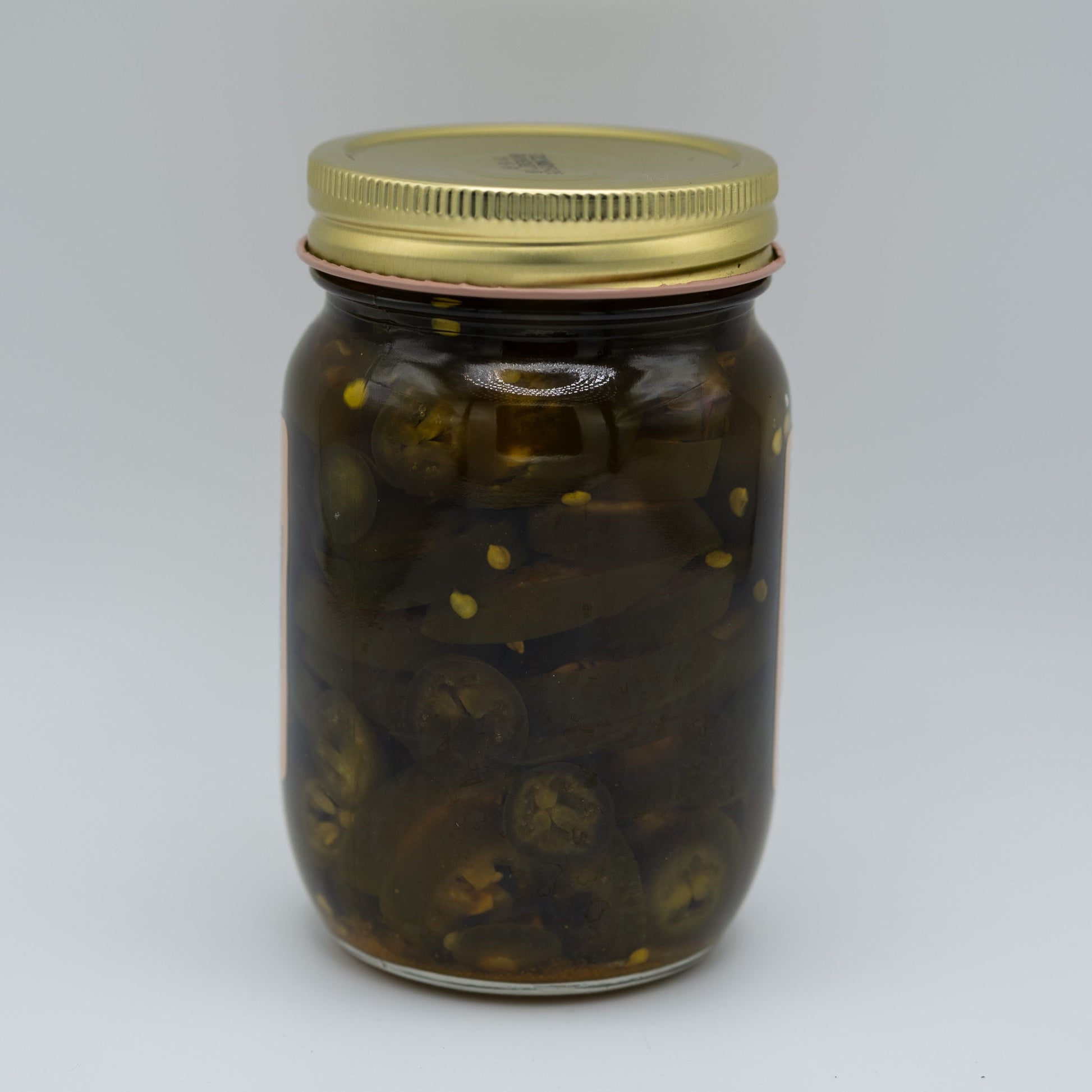 Canned candied jalapenos in a jar, Amish Country Store branded, showing glossy green jalapenos coated with sweet syrup.