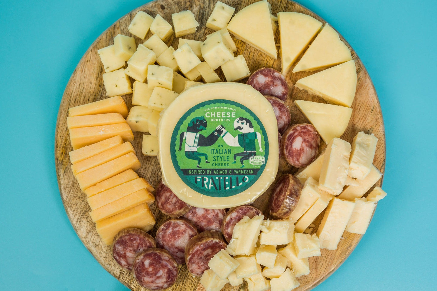 Assorted cheese and charcuterie meats in a gift box from Cheese Brothers, Inc. with crackers and fresh accompaniments.