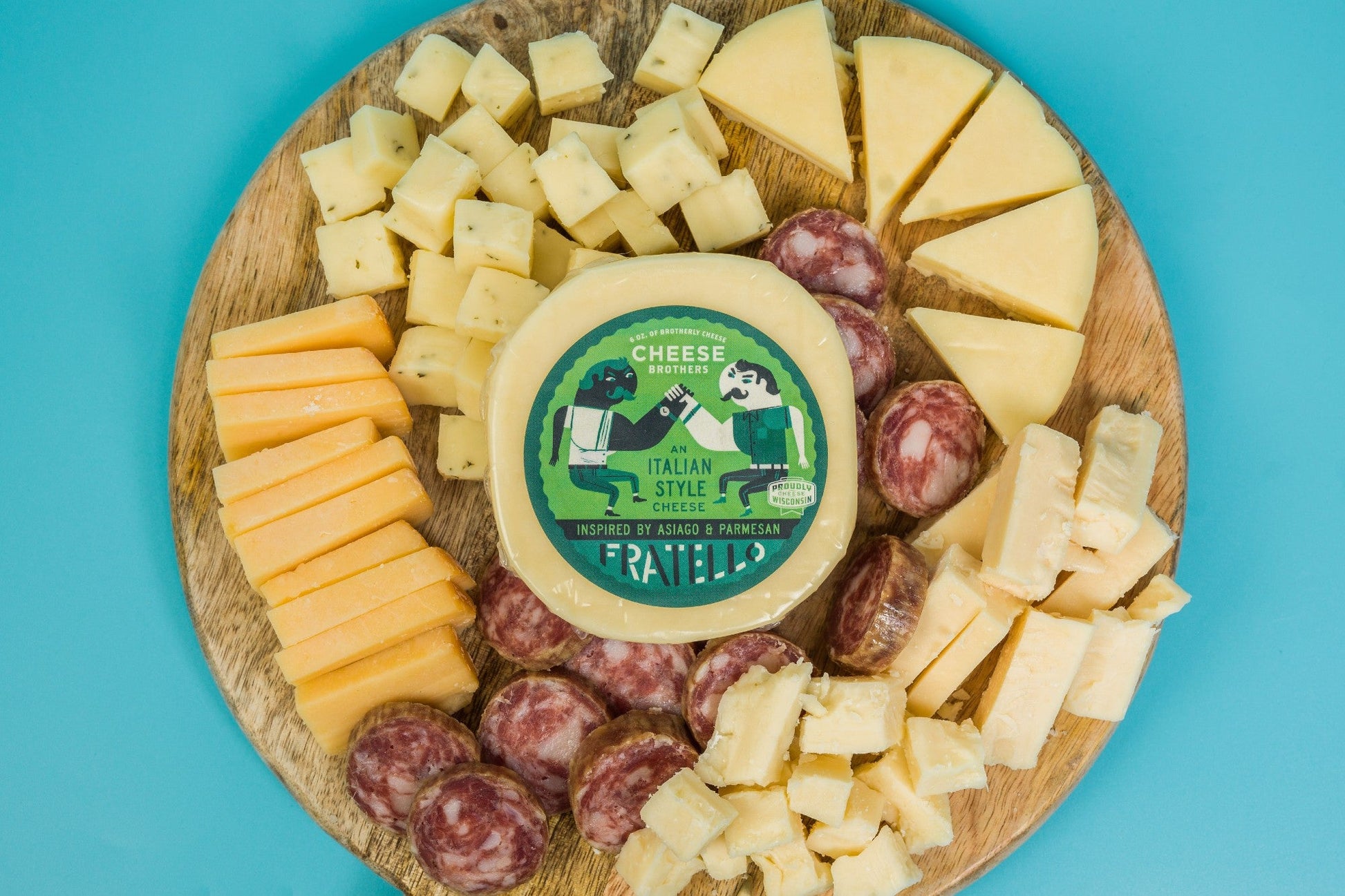 Assorted cheese and charcuterie meats in a gift box from Cheese Brothers, Inc. with crackers and fresh accompaniments.
