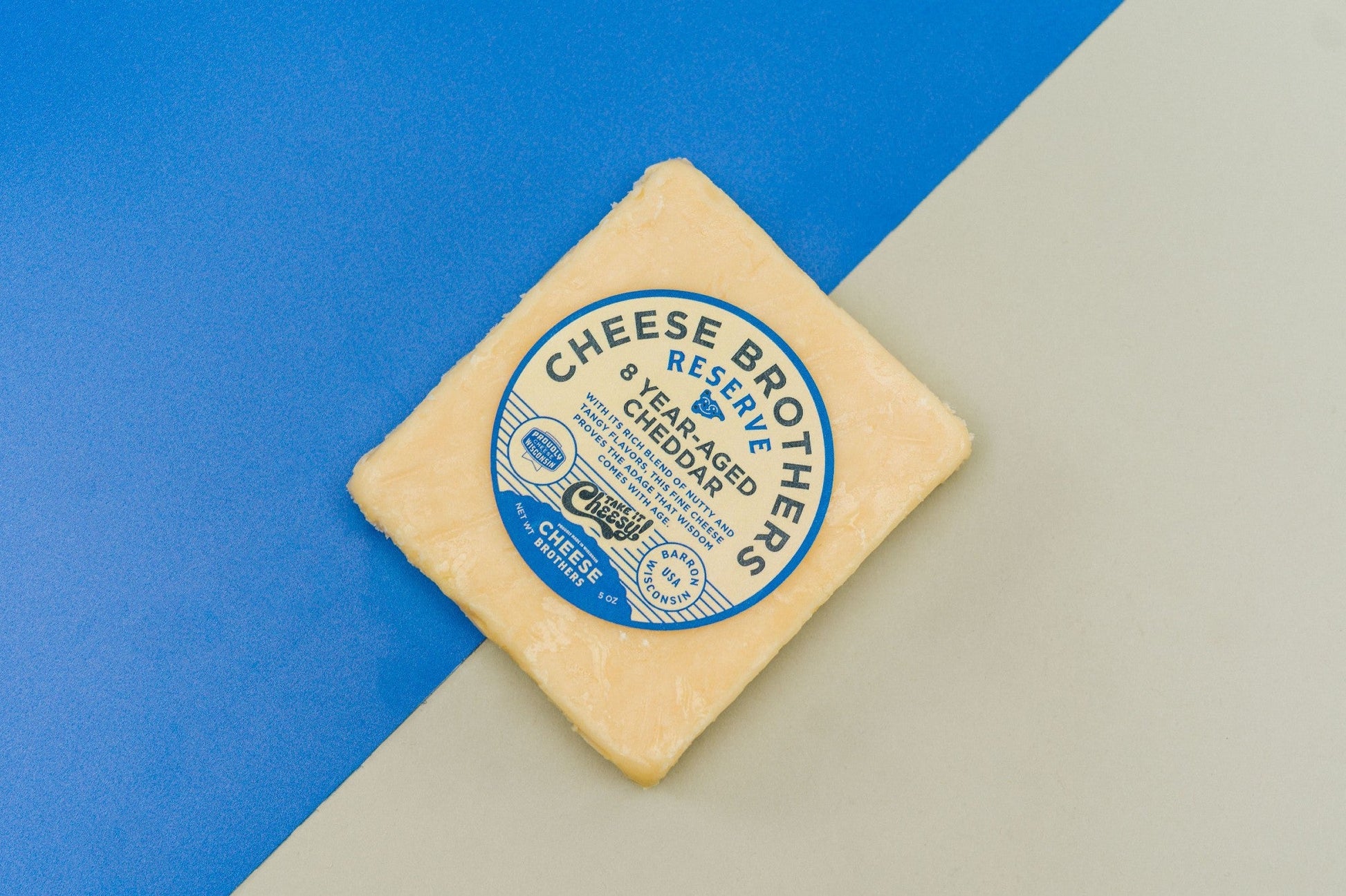 8-year-aged cheddar cheese from Cheese Brothers, Inc., showing a block of rich, firm aged cheese with a golden hue.