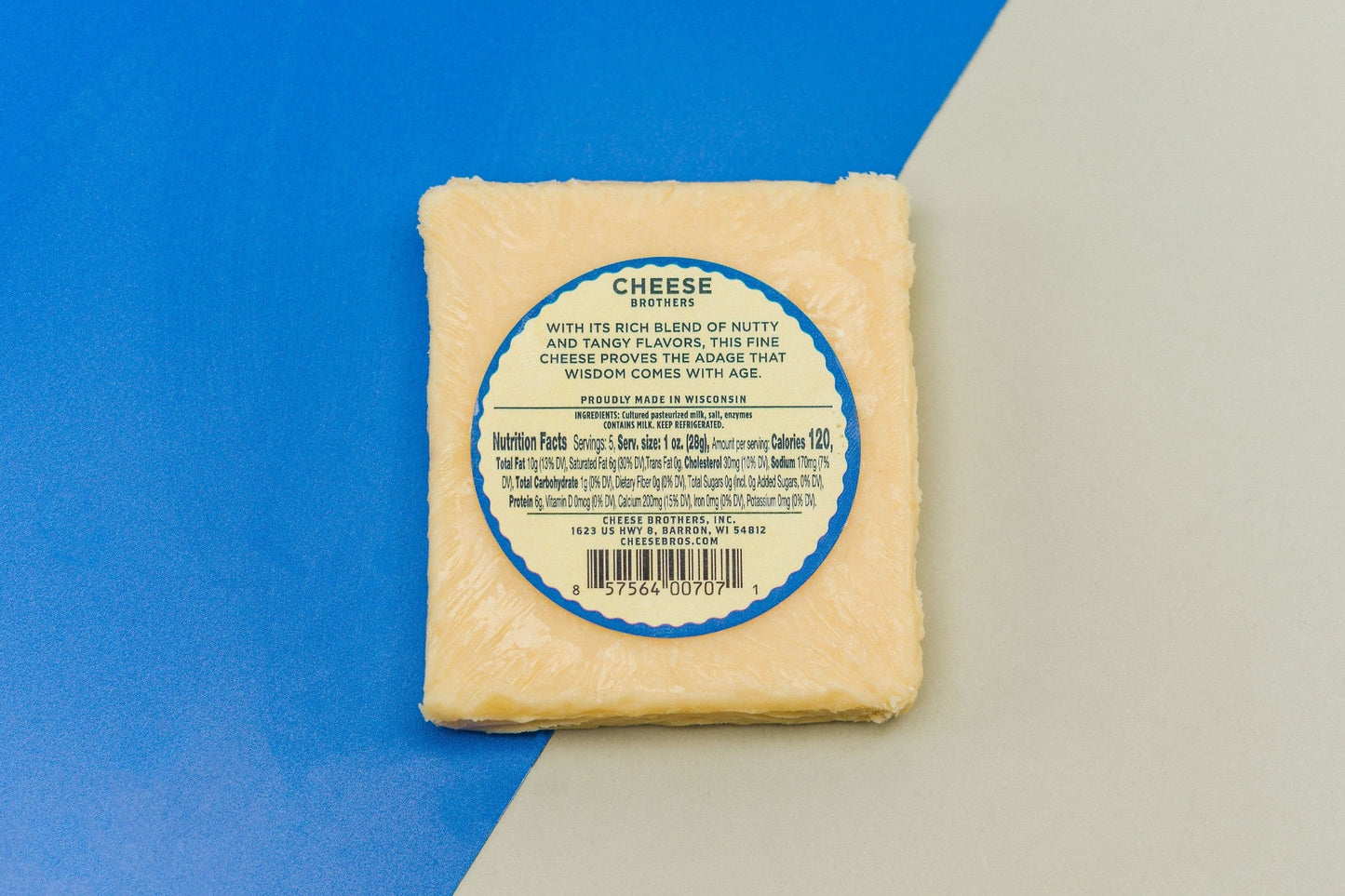 Aged 8-year cheddar cheese block from Cheese Brothers, Inc., showcasing its rich, firm texture and golden color.