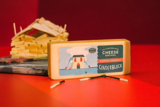 Smoked Cheddar cheese block from Cheese Brothers, Inc. with rich, golden-yellow color and smooth texture visible in the image.