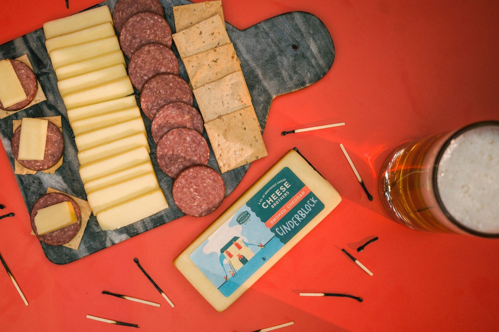 Smoked cheddar cheese block from Cheese Brothers, Inc., showing creamy texture and rich smoked flavor.