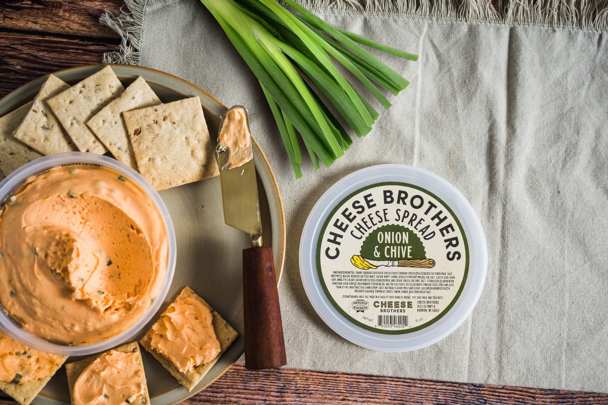 Creamy Onion and Chive Cheese Spread by Cheese Brothers, Inc. in a jar with visible herbs and smooth texture.