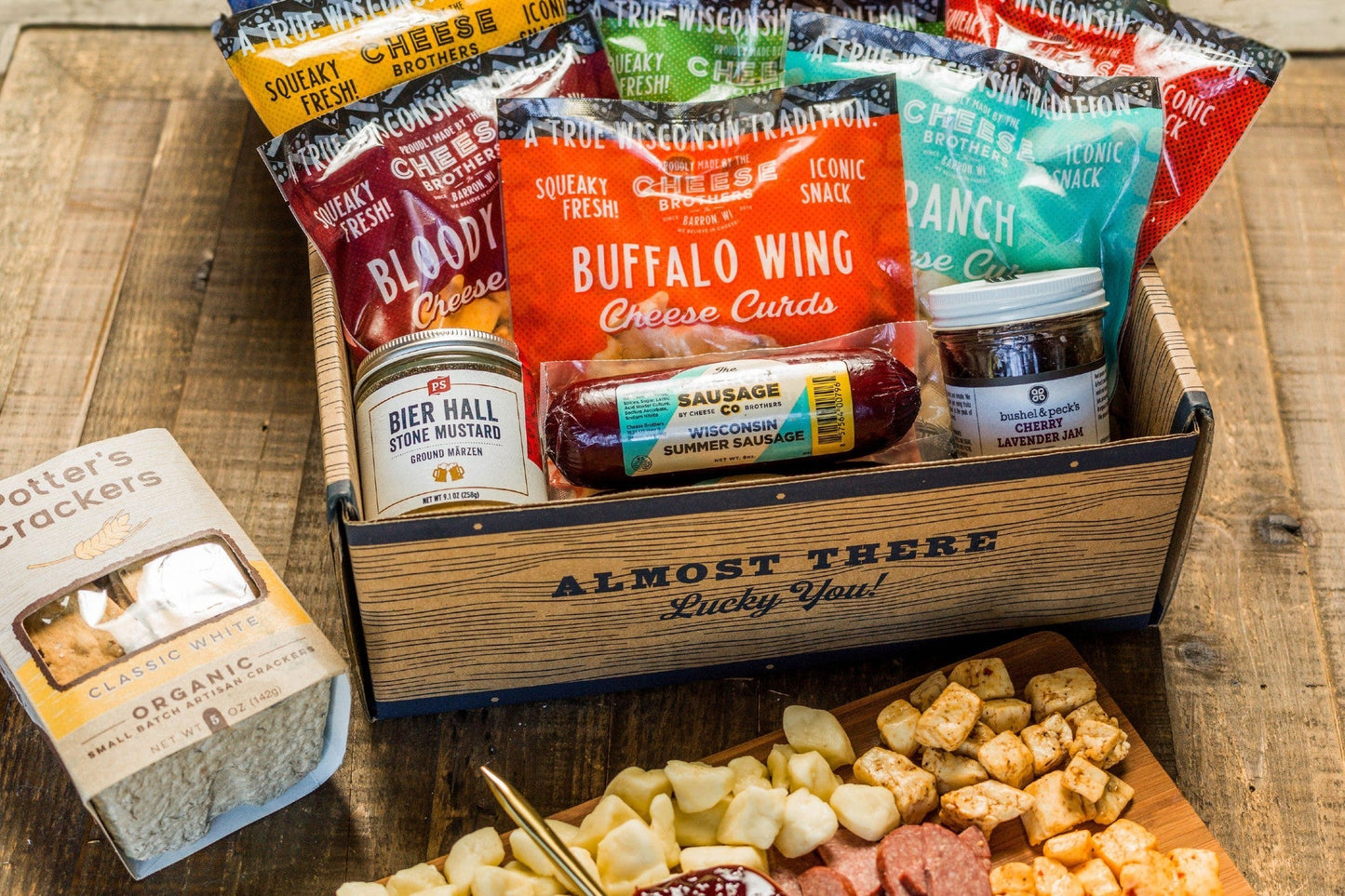 Cheese Brothers Inc. Deluxe Char-Curd-Erie Box featuring assorted cheeses, charcuterie, and gourmet accompaniments in an elegant gift bundle.