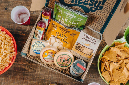 Cheese Brothers Inc. Deluxe Game Day Essentials Gift Pack featuring assorted cheeses, snacks, and condiments for game day celebrations.