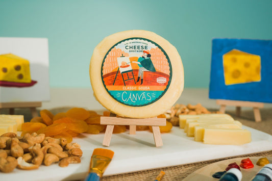 Slices of classic Gouda cheese from Cheese Brothers, Inc., showcasing its smooth, golden interior and firm texture.