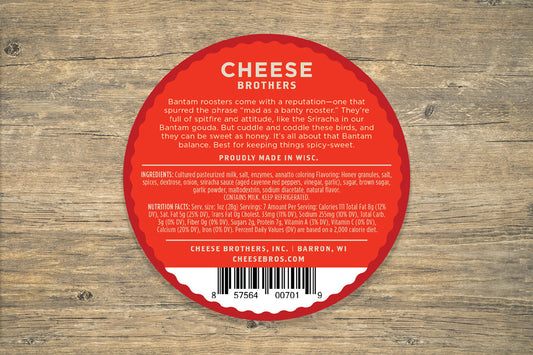 Honey Sriracha Gouda cheese by Cheese Brothers, Inc., showing a wedge of flavorful honey-sriracha Gouda cheese on a wooden board.