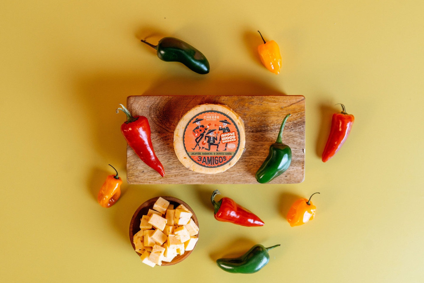 Smoked 3 Amigos Spicy Gouda cheese by Cheese Brothers, Inc. with a rich, smoky appearance and hints of spice.