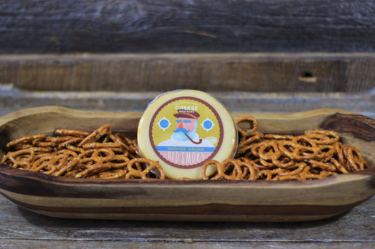 Smoked Gouda cheese by Cheese Brothers, Inc., showing a block of rich, smoked Gouda cheese with a smooth, golden-brown rind.