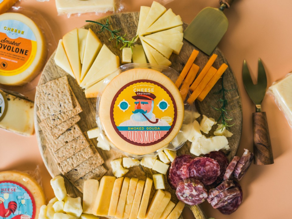 Sliced smoked Gouda cheese from Cheese Brothers Inc., showcasing its rich, smoky flavor and smooth texture.