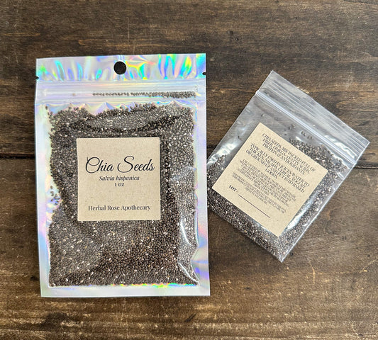 Dried chia seeds from HerbalRoseApothecary in a clear jar, showing small, oval, grayish-black seeds on a neutral background.