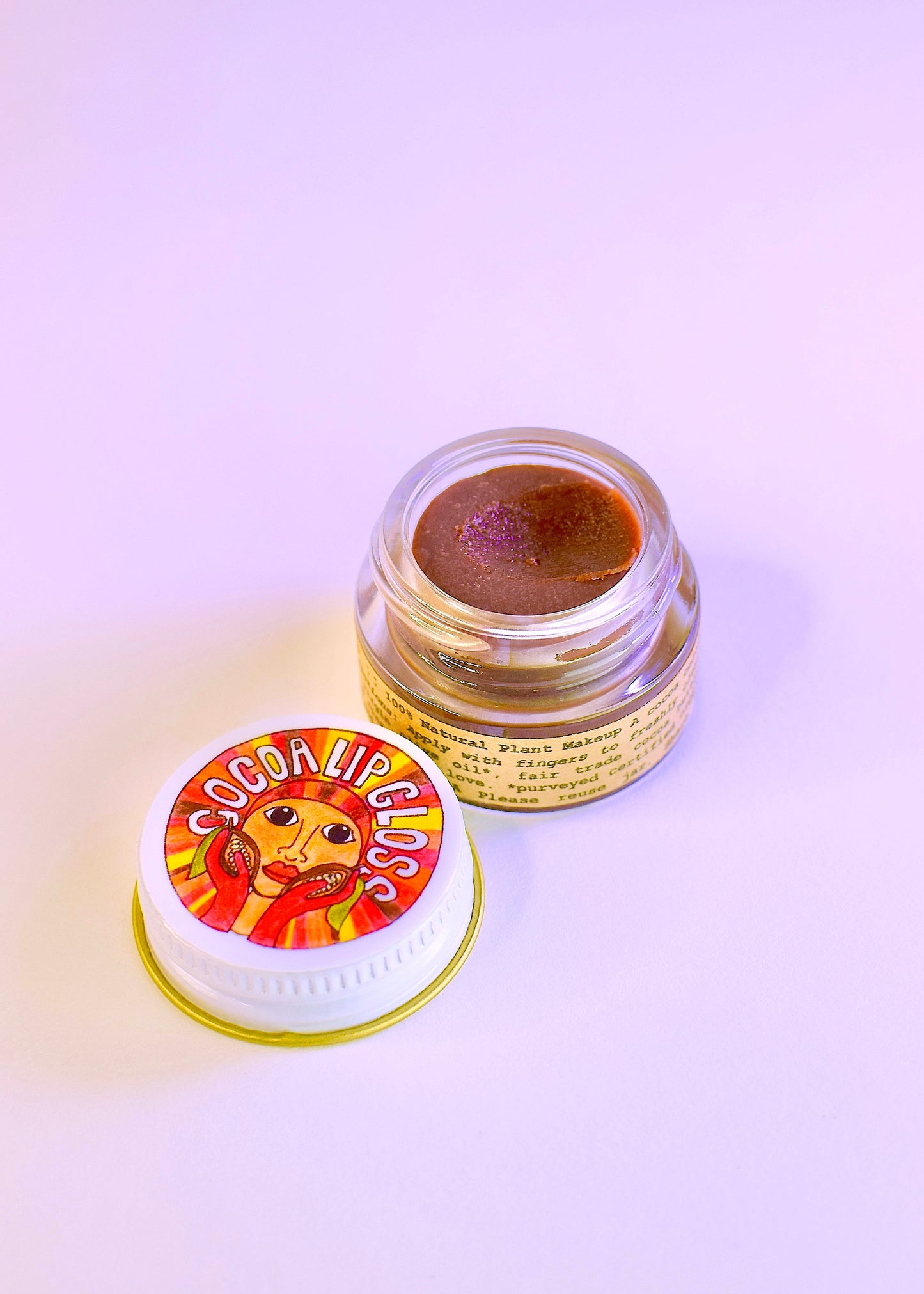 Plant Makeup Cocoa Lip Gloss in a clear tube with a glossy finish, showing the rich cocoa shade and smooth applicator.