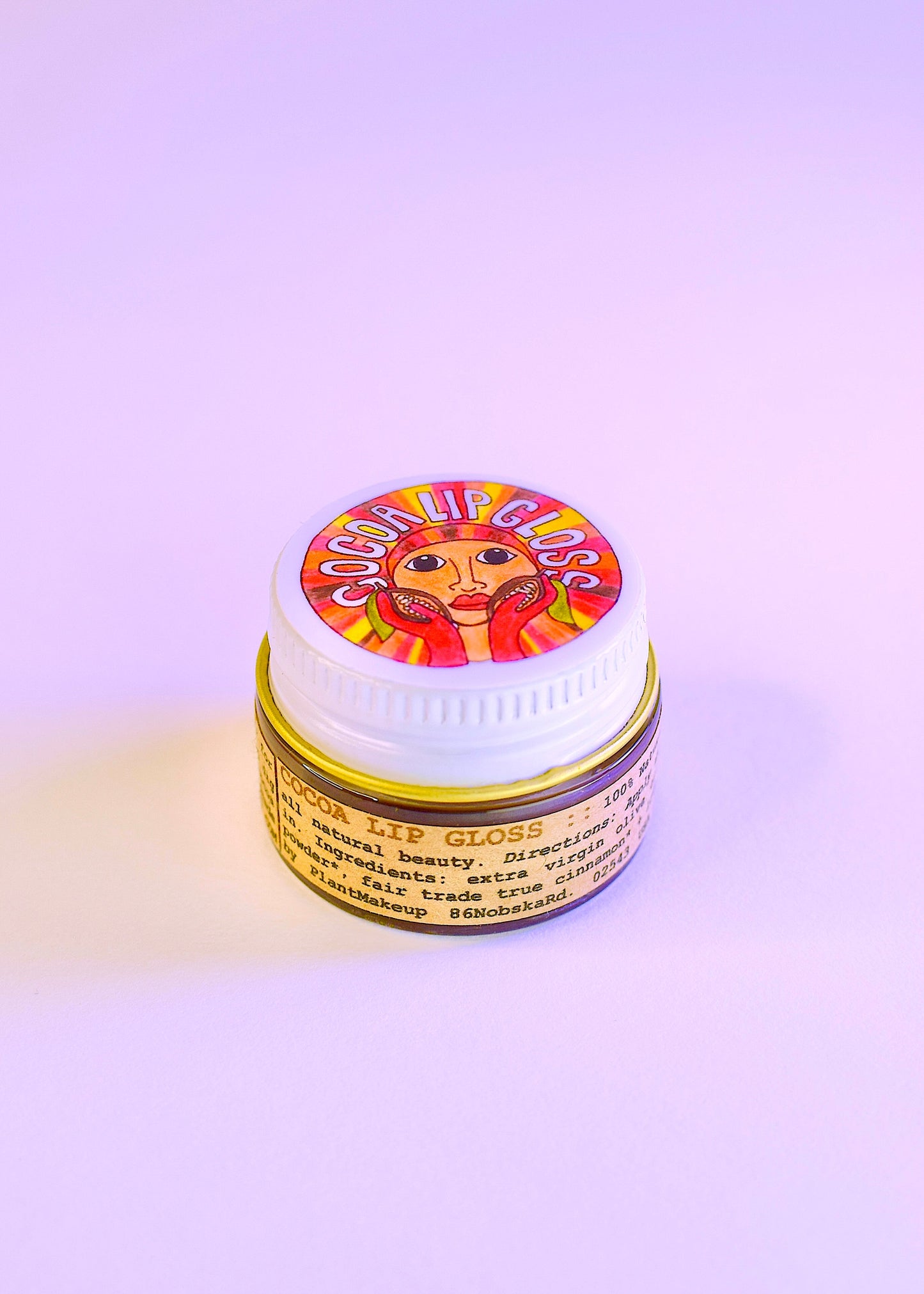Plant Makeup Cocoa Lip Gloss tube with a shiny, smooth finish, showcasing the natural cocoa-inspired lip gloss product.