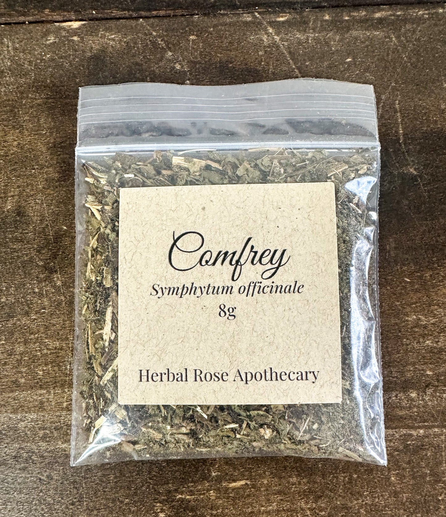 Dried comfrey herbs in an herbalroseapothecary package, showing green leaves and dried plant material for herbal remedies.