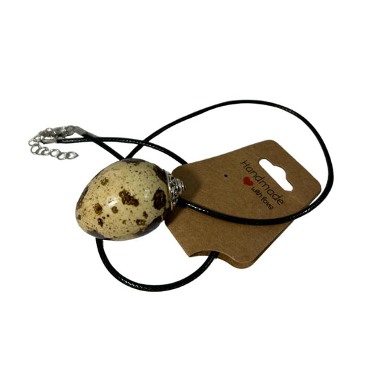 Close-up of a delicate Quail Egg Necklace featuring a small quail egg pendant on a fine chain, styled for elegance.