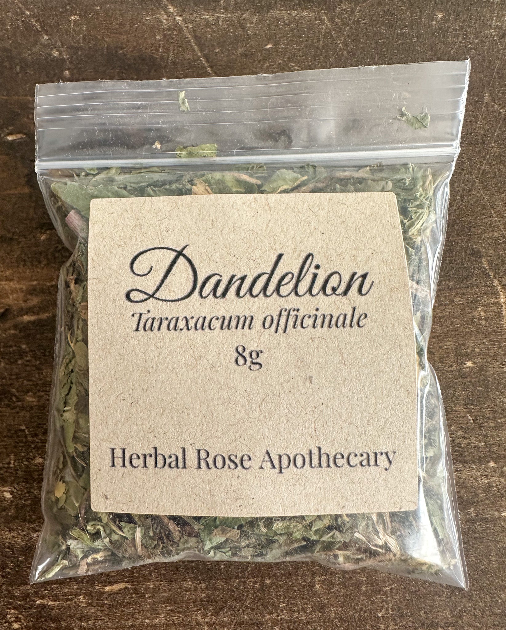 Dried dandelion herbs in an 8g package from Herbal Rose Apothecary, showing yellow flowers and green leaves.