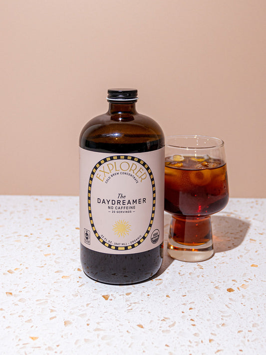 Explorer Cold Brew 32oz cold brew coffee concentrate in a clear bottle with daydreamer branding, ready for brewing or serving.