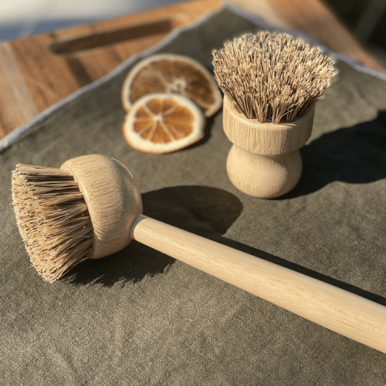 Eco-friendly bamboo dishwashing brush with handle and palm fiber bristles, ideal for eco-conscious kitchen utensils.