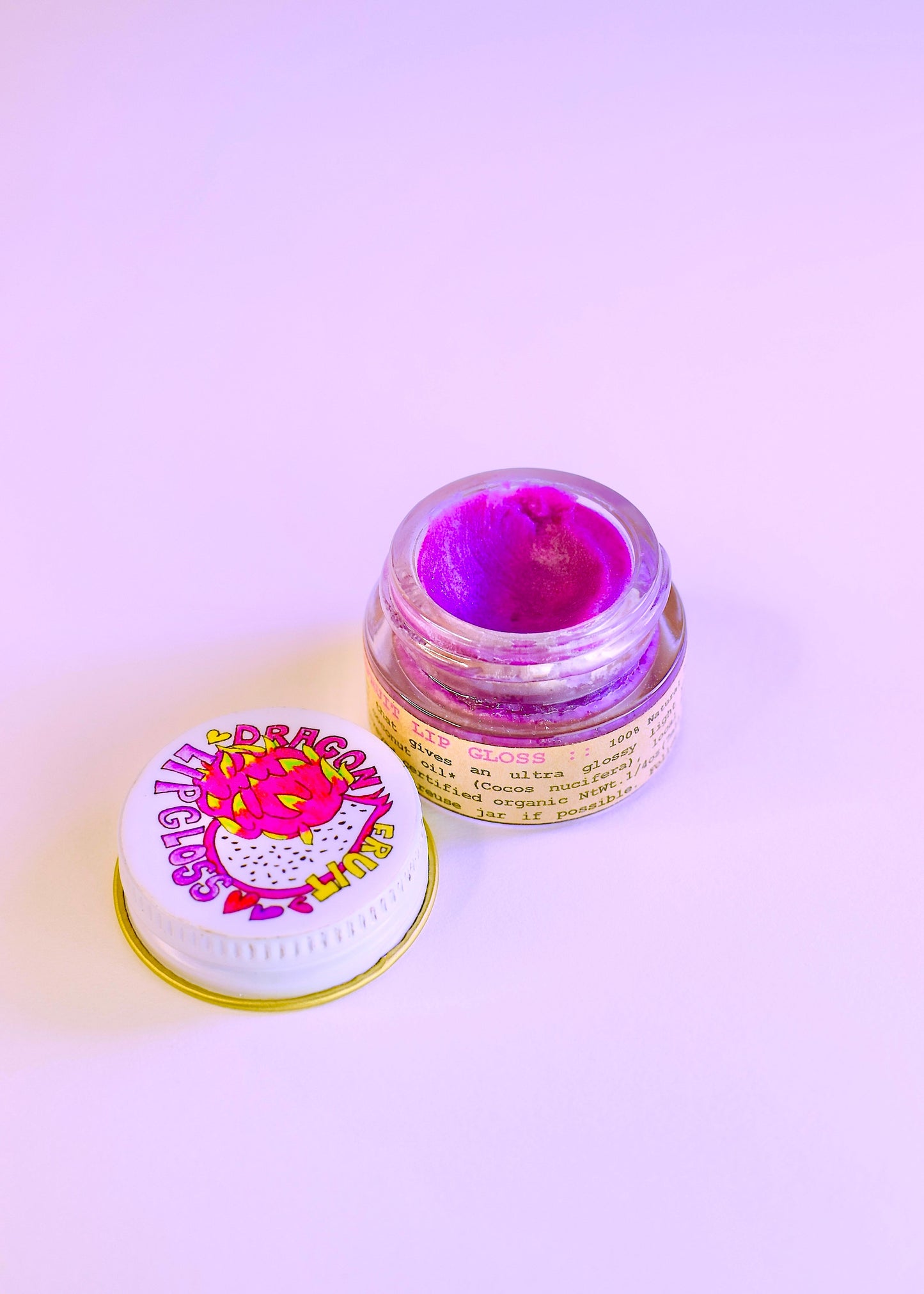 Plant Makeup Dragon Fruit Lip Gloss in a sleek tube, featuring vibrant pink packaging and the glossy finish of the lip gloss.