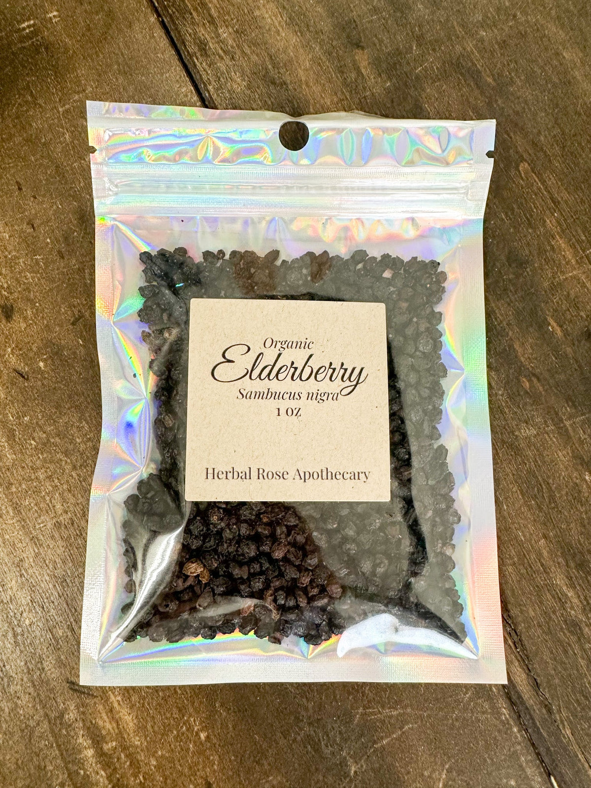 Dried organic elderberries in a 1oz package from Herbal Rose Apothecary, showing small dark berries suitable for herbal remedies.