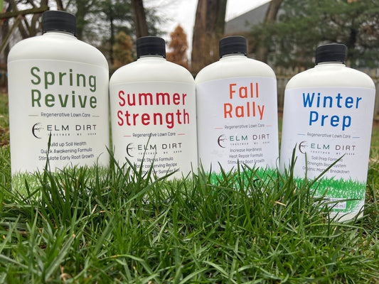 Four bottles of Regenerative and Sustainable Lawn Care by Elm Dirt—Spring Revive, Summer Strength, Fall Rally, and Winter Prep—stand on green grass, highlighting the brand’s microbe-rich fertilizers with trees blurred behind.